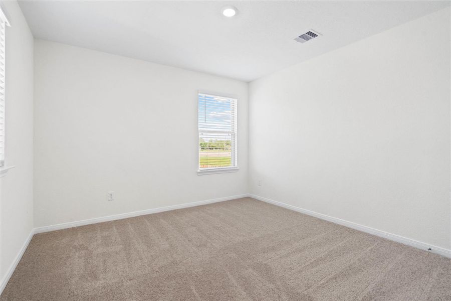 This secondary bedroom combines comfort and style, featuring plush carpeting, neutral paint, recessed lighting, a large window with blinds, and a spacious closet. This secondary bedroom combines comfort and style, featuring plush carpeting, neutral paint, recessed lighting, a large window with blinds, and a spacious closet.