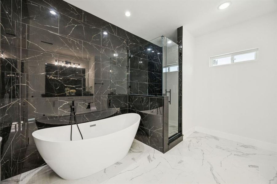 Full bathroom featuring a soaking tub, marble tiled floors, tile walls, a marble finish shower, and recessed lighting