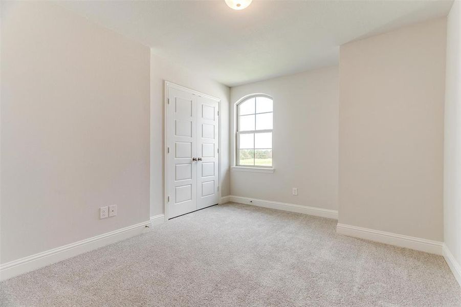 Unfurnished room with light colored carpet and baseboards