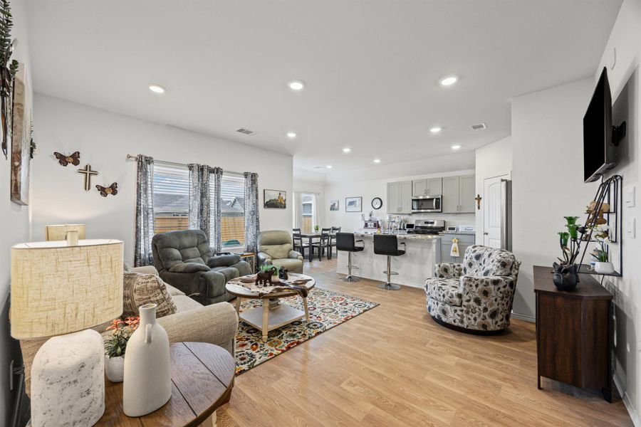 Living room with light wood finished floors and recessed lighting