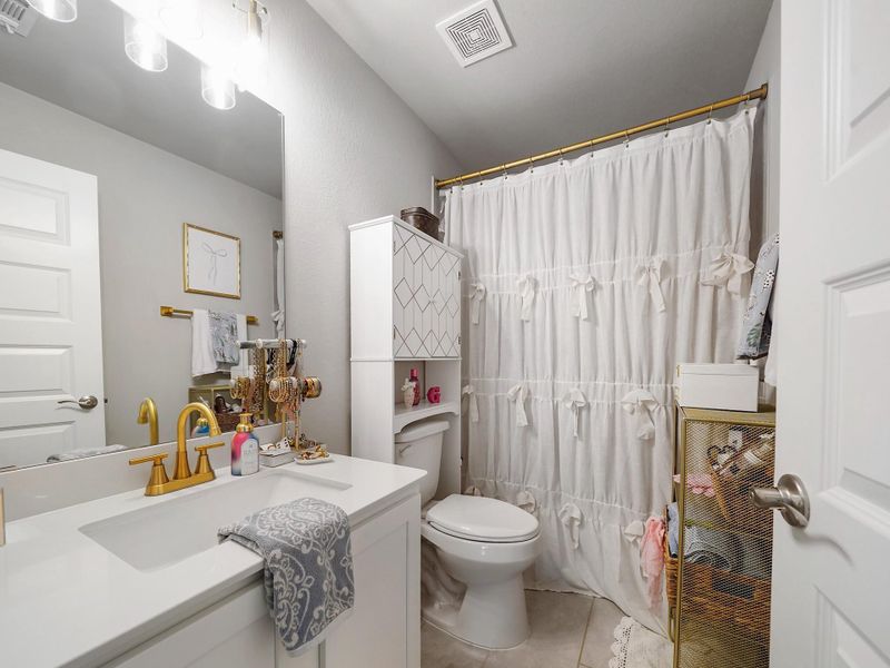 The secondary bathroom features a clean, neutral design with updated fixtures that complement the home’s cohesive style.