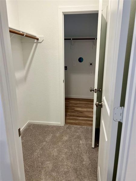 Laundry room through primary bedroom