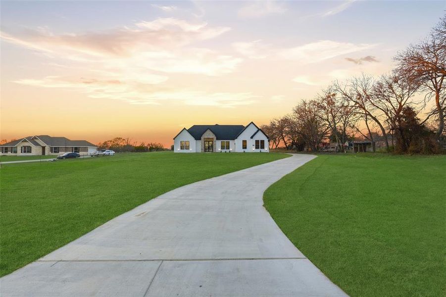 View of front of house featuring a front lawn and concrete driveway