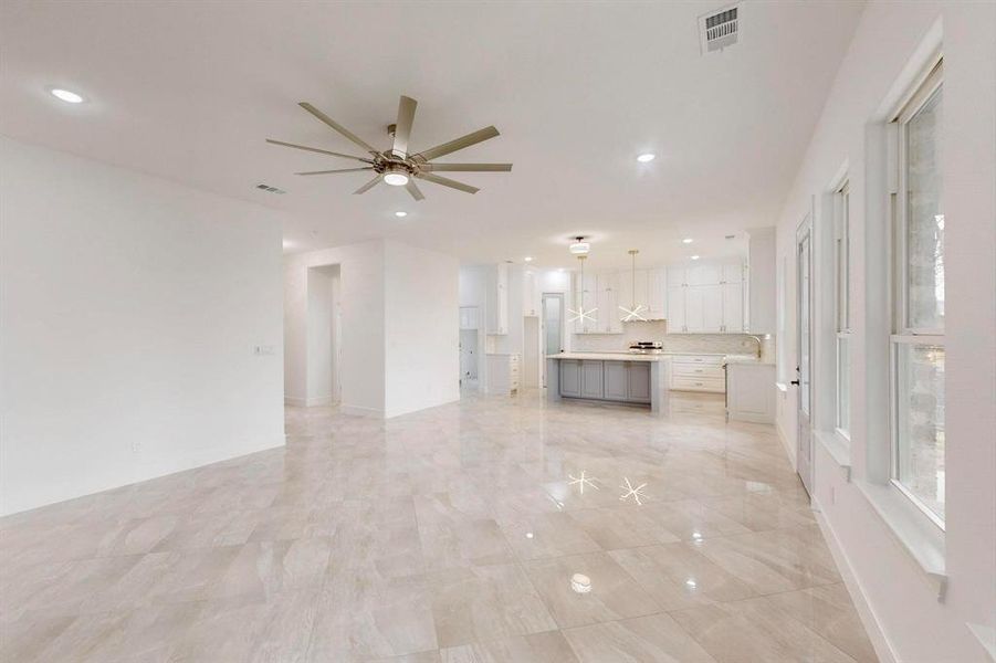 Unfurnished living room featuring a ceiling fan and recessed lighting
