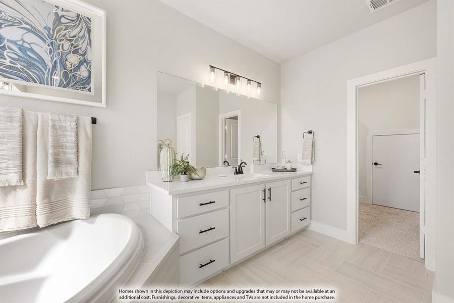 Master bathroom with double vanity, soaking tub, white cabinets, and large mirror with modern light fixture.