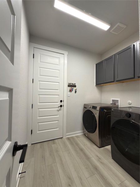 Light wood-finish flooring with white baseboards throughout