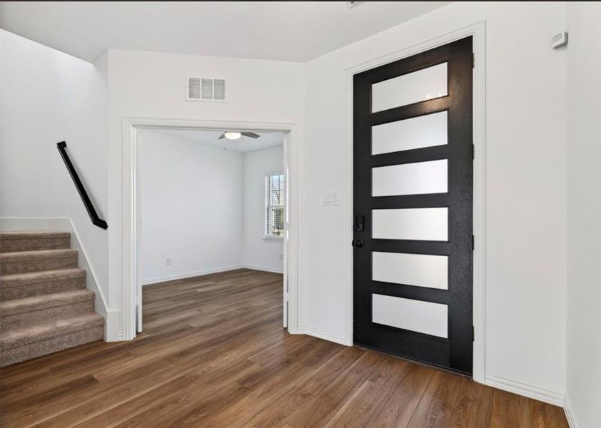 Entrance foyer with dark wood-style flooring and stairs