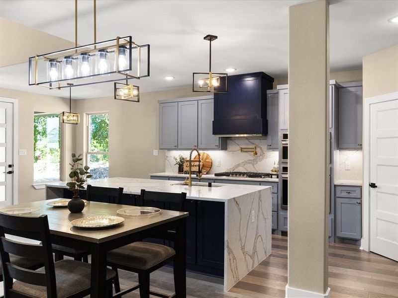 Kitchen with a kitchen island with sink, pendant lighting, dark wood-type flooring, light stone countertops, and decorative backsplash