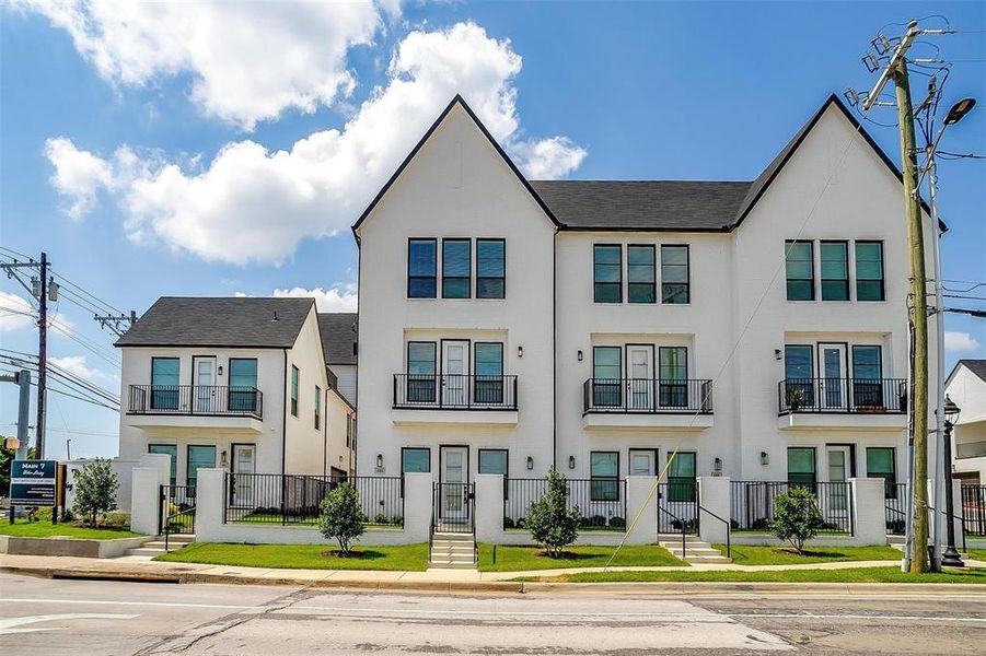 Townhome / multi-family property featuring a fenced front yard and stucco siding