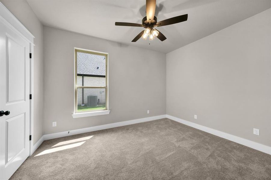 Carpeted spare room with ceiling fan