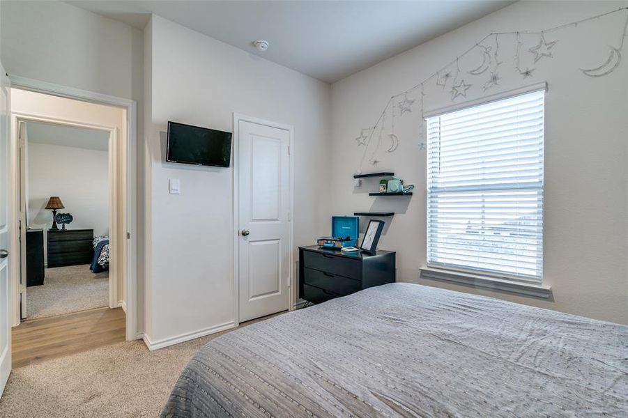 Bedroom featuring multiple windows and light colored carpet