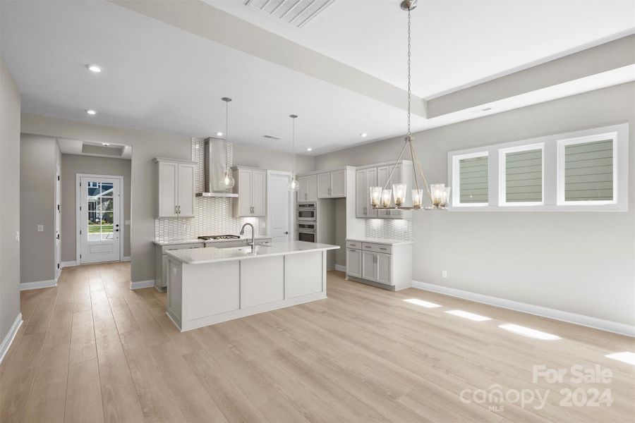 GOURMET Kitchen Cabinet and Appliance Configuration with Quartz countertop and EVP Flooring. Farmhouse Cast Iron Kitchen Sink.