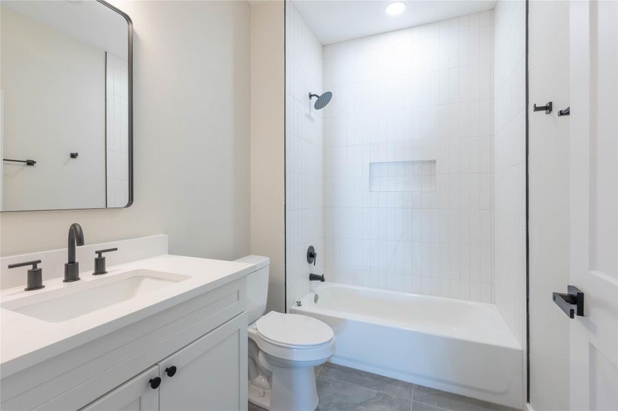 Bathroom featuring vanity, shower / washtub combination, and tile patterned flooring