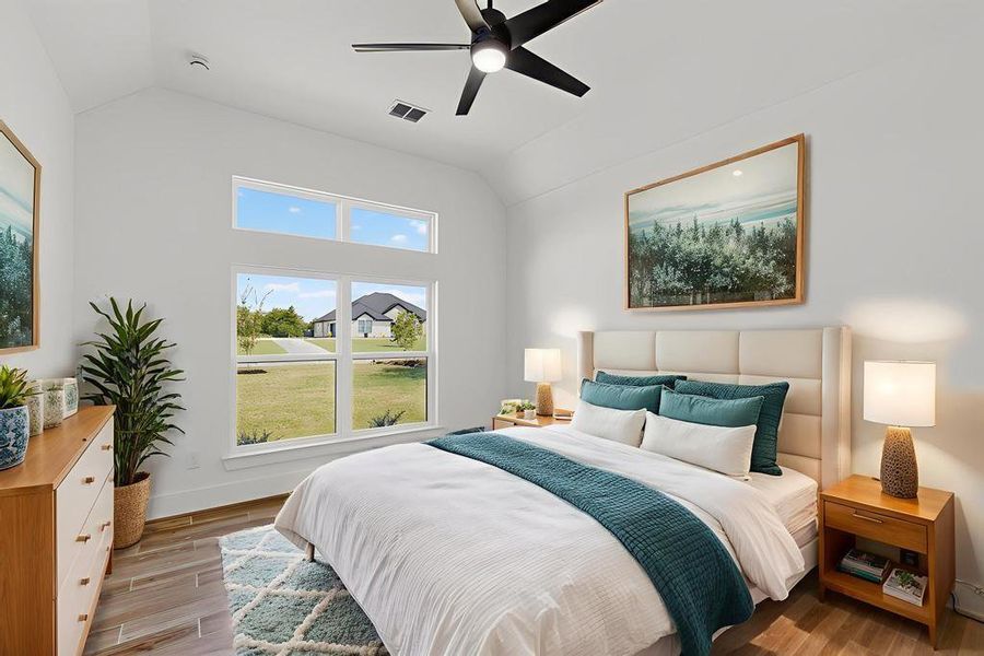 Bedroom featuring lofted ceiling, light wood finished floors, and a ceiling fan