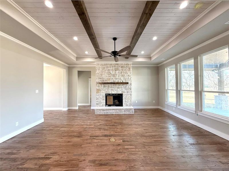 Unfurnished living room with recessed lighting, a wood ceiling with exposed beams, dark wood-type flooring, ornamental molding, and ceiling fan Unfurnished living room with recessed lighting, a wood ceiling with exposed beams, dark wood-type flooring, ornamental molding, and ceiling fan