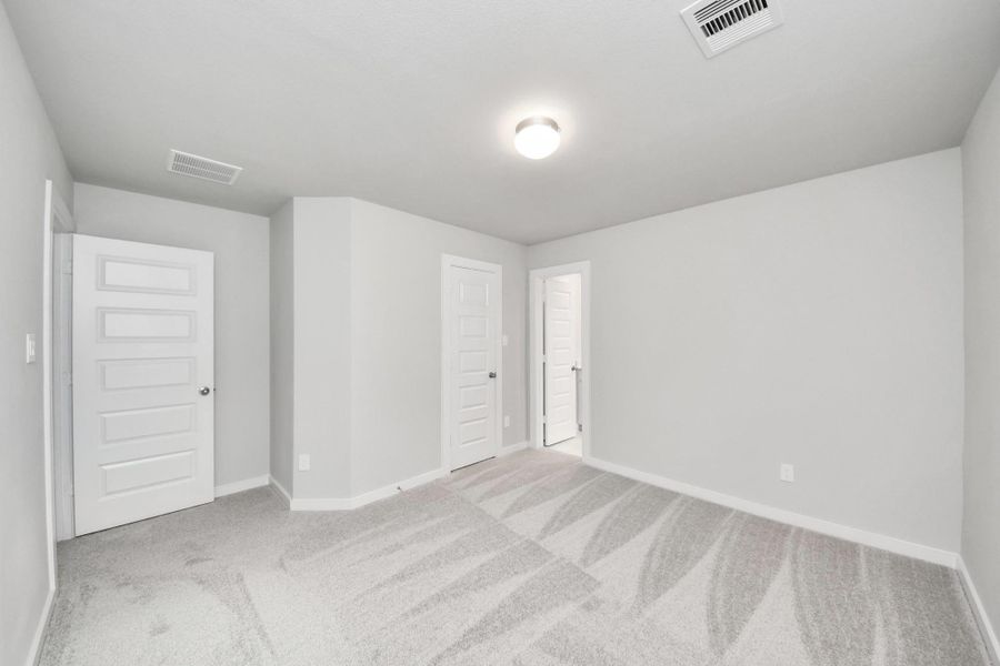 Secondary bedroom features plush carpeting, large windows that let in plenty of natural light, bright paint, and spacious closets. Sample photo of completed home with similar floor plan. Actual colors and selections may vary. Secondary bedroom features plush carpeting, large windows that let in plenty of natural light, bright paint, and spacious closets. Sample photo of completed home with similar floor plan. Actual colors and selections may vary.