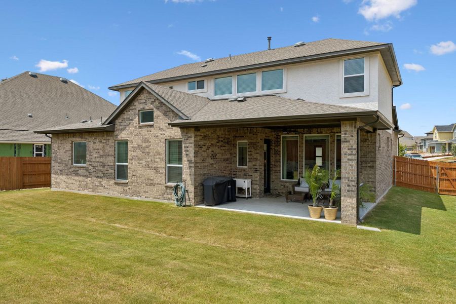 Brick and stucco finishes define this two-story exterior featuring a covered back patio.