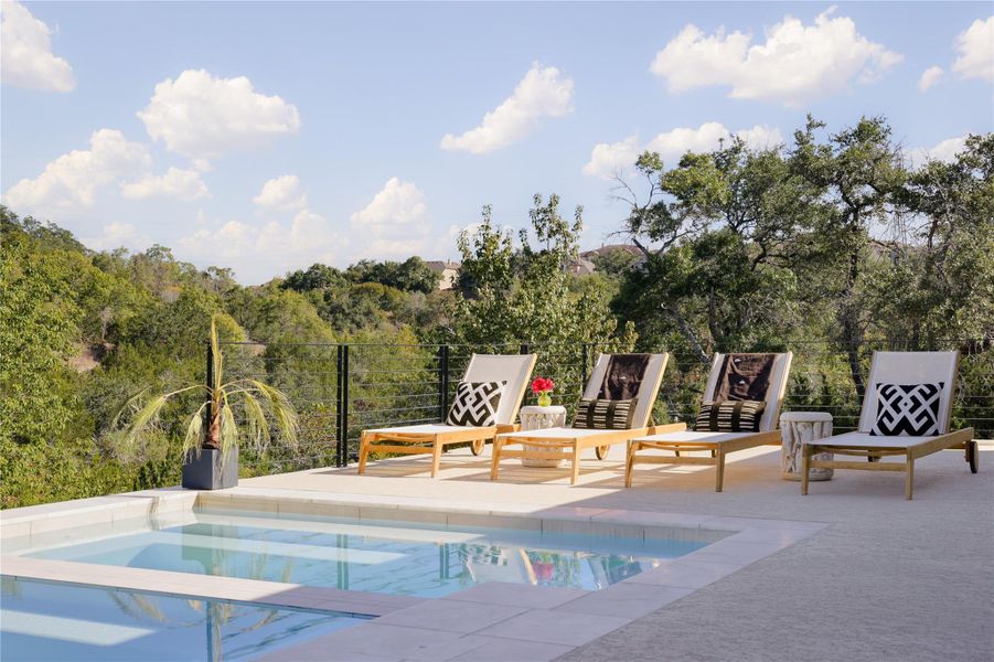 The outdoor pool and spa create a lavish retreat, where you can soak in the warmth of the sun while enjoying breathtaking vistas of the verdant greenbelt