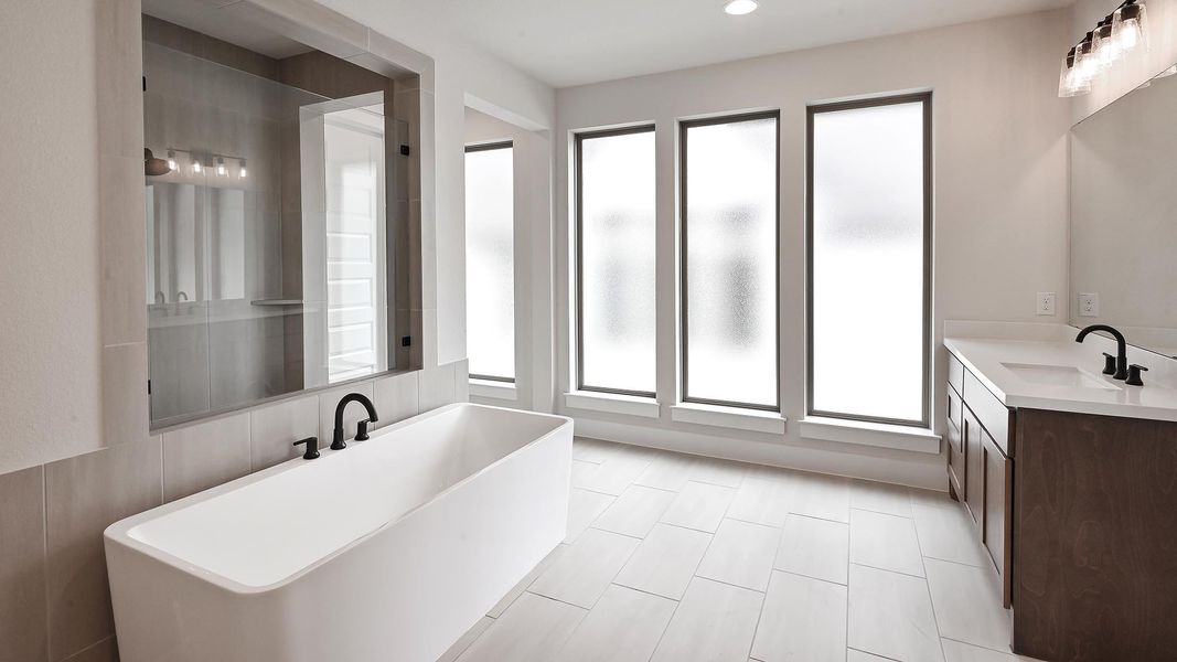 Full bath featuring a soaking tub, double vanity, tile patterned flooring, and recessed lighting Full bath featuring a soaking tub, double vanity, tile patterned flooring, and recessed lighting