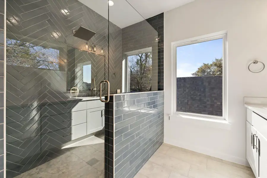 Bathroom featuring a tile Primary shower, a wealth of natural light, and vanity