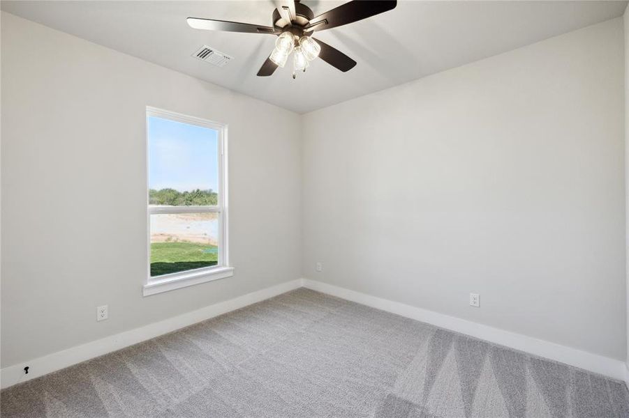 Empty room featuring ceiling fan and carpet flooring