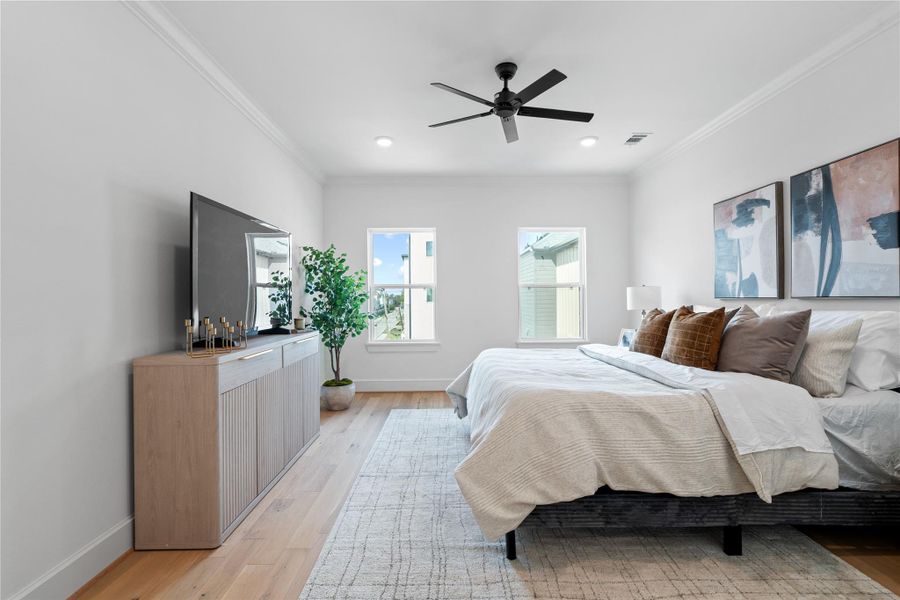 Spacious primary bedroom on the third floor featuring hardwood floors, ample natural light, and a serene atmosphere - perfect for relaxing at the end of the day.