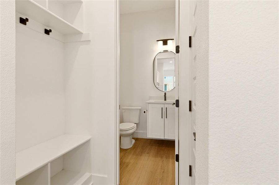 Bathroom with vanity, light wood-type flooring, and a textured wall