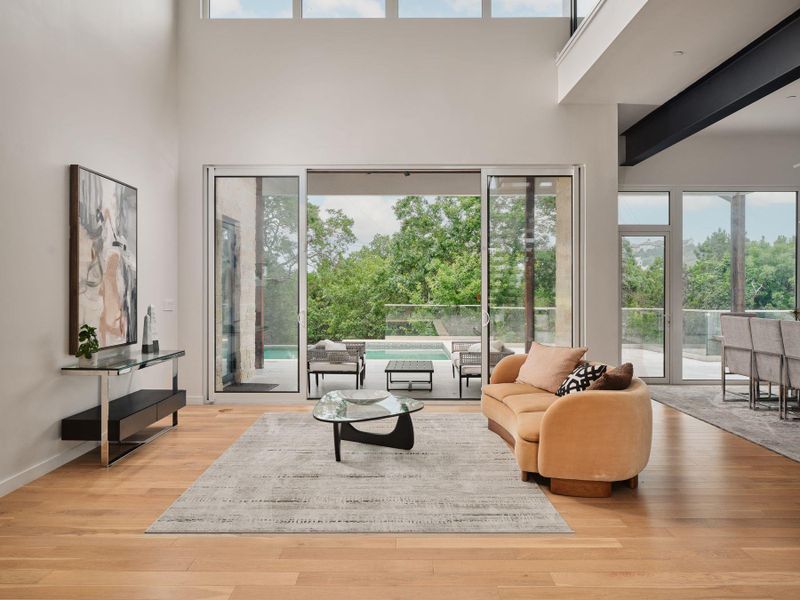 Natural light floods this living area, offering grand views of the surrounding green landscape. Natural light floods this living area, offering grand views of the surrounding green landscape.
