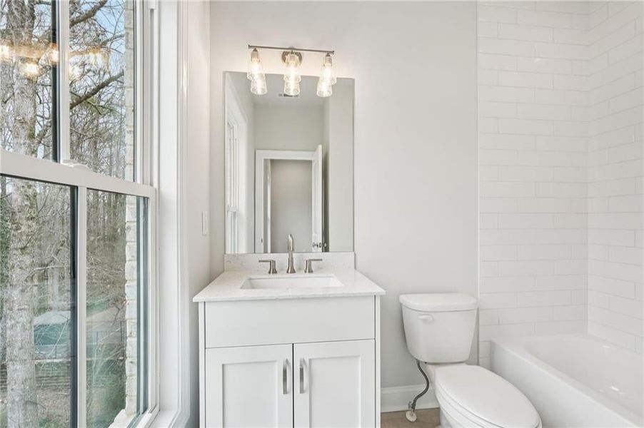 Full bathroom with vanity, healthy amount of natural light, and bathtub / shower combination