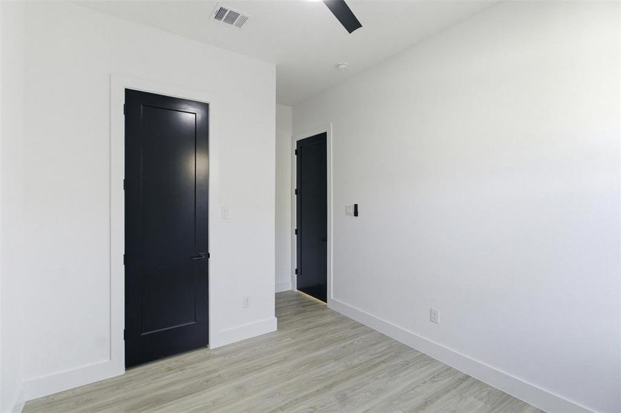 Unfurnished bedroom featuring light wood-style flooring, ceiling fan, and a closet
