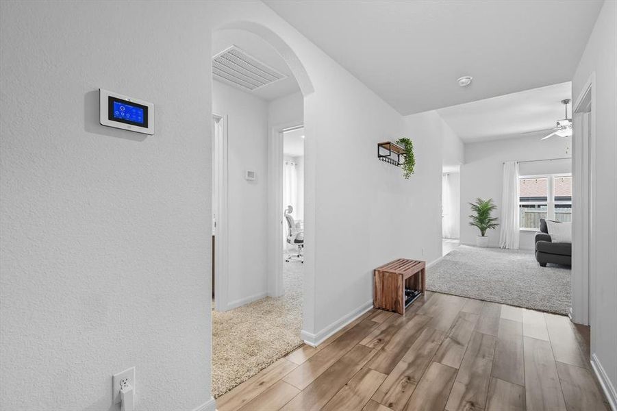 Corridor with arched walkways and light wood-style floors