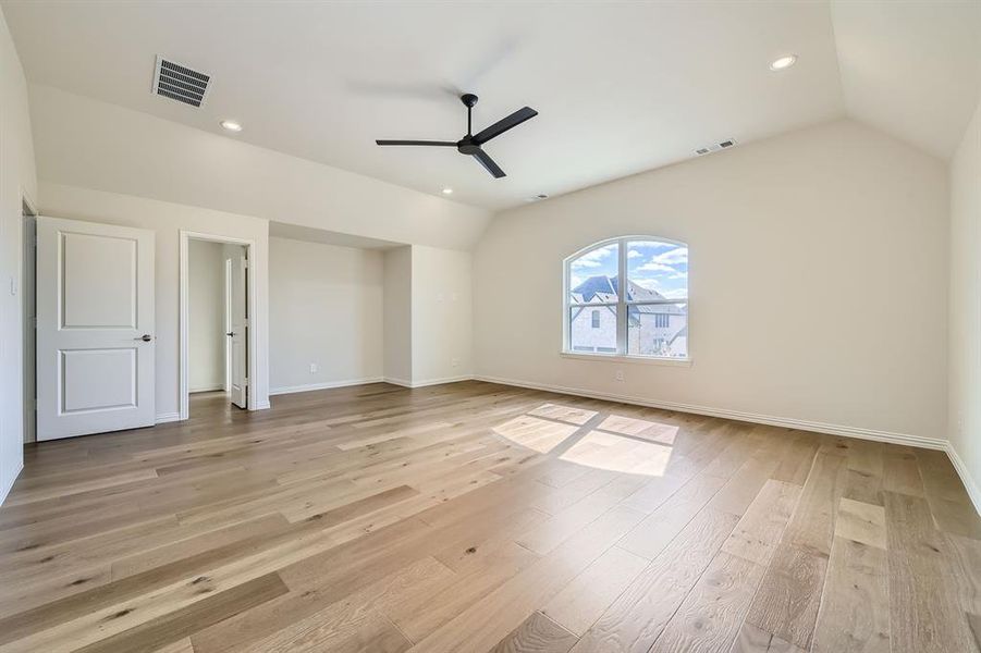 Large bonus room with ceiling fan, light hardwood / wood-style flooring, and lofted ceiling