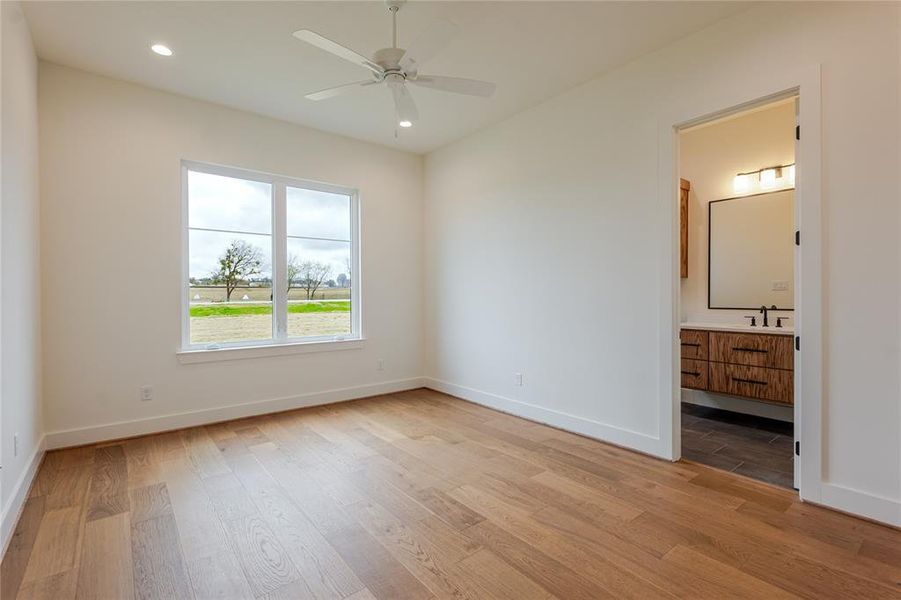Unfurnished bedroom with light wood finished floors, ceiling fan, connected bathroom, and recessed lighting