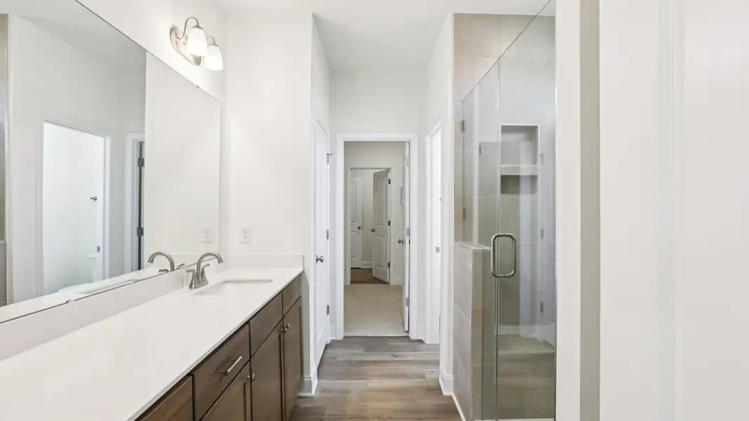Pendleton home plan primary bathroom with tile shower, dual vanities and linen closet Pendleton home plan primary bathroom with tile shower, dual vanities and linen closet