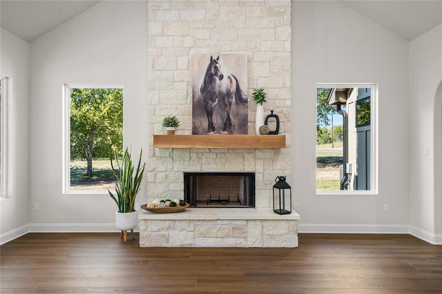 Unfurnished living room with lofted ceiling, dark wood-style flooring, and a fireplace
