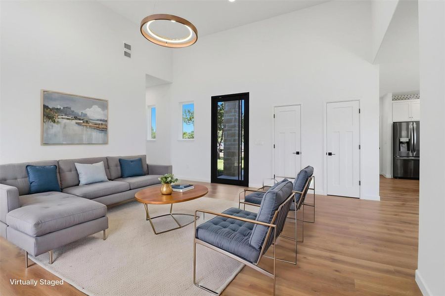 Spacious living area featuring a vaulted ceiling and wood-finish flooring Spacious living area featuring a vaulted ceiling and wood-finish flooring
