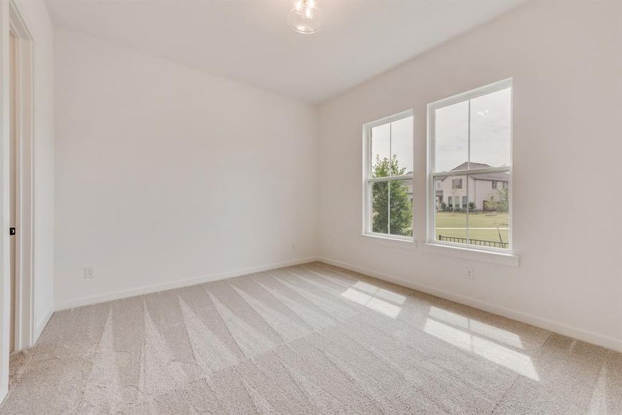 Unfurnished room with light carpet and baseboards Unfurnished room with light carpet and baseboards