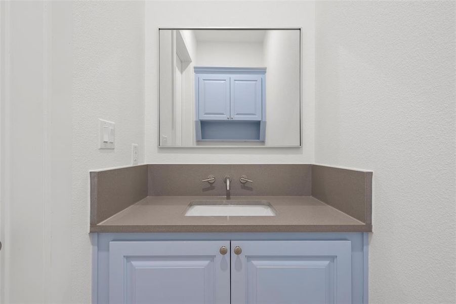 Bathroom with a textured wall and vanity Bathroom with a textured wall and vanity