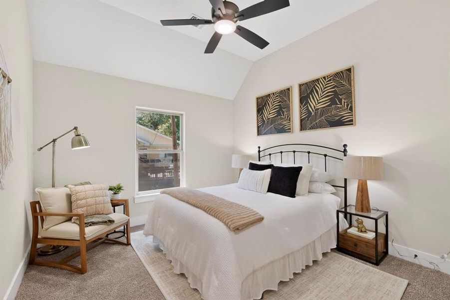Vaulted ceiling room featuring a ceiling fan with integrated lighting, a single window, and carpet flooring