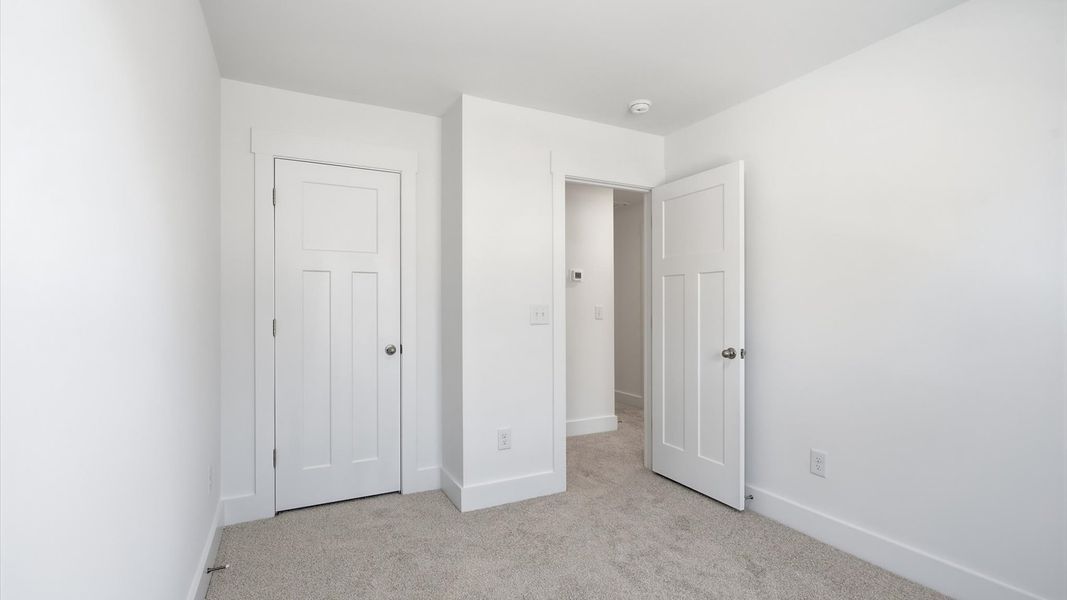 Superior comfort in a secondary bedroom with plush carpet and an oversized walk-in closet at Clarke Townes