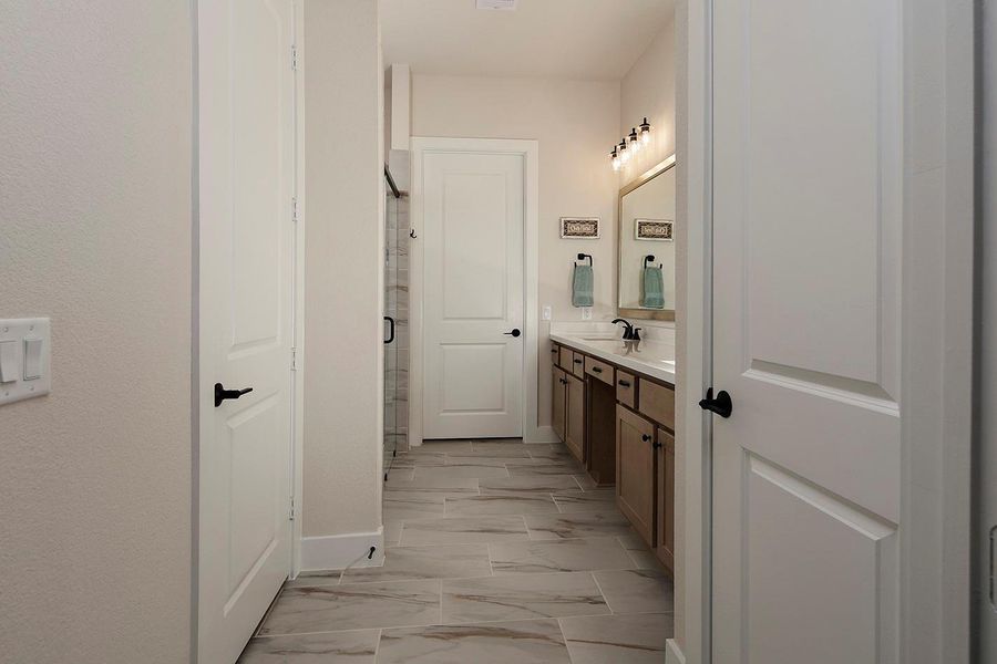 Primary bath w lovely tile floors, rich cabinets; frameless glass shower doors Primary bath w lovely tile floors, rich cabinets; frameless glass shower doors