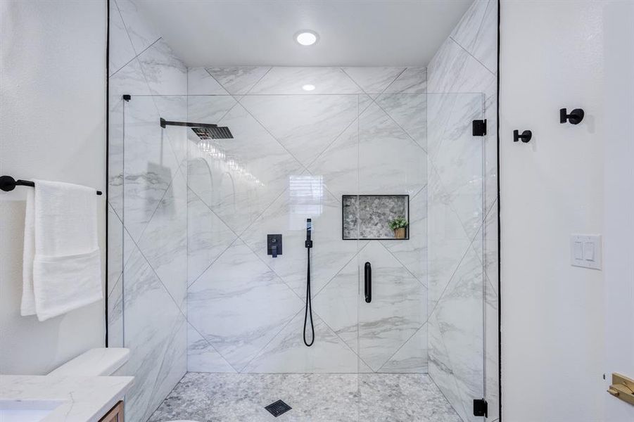 Bathroom featuring vanity, toilet, and walk in shower