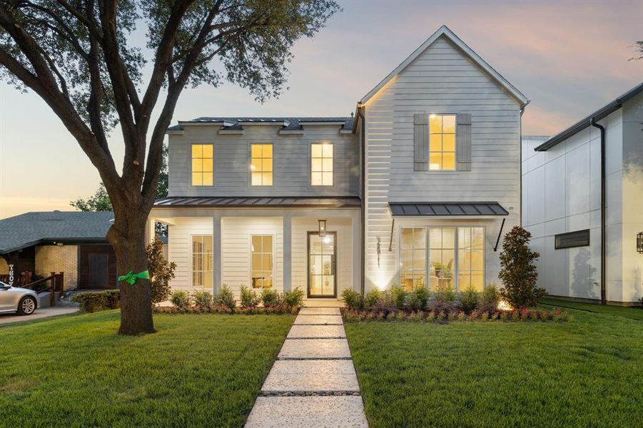 View of front of property with a standing seam roof, a metal roof, and a front yard