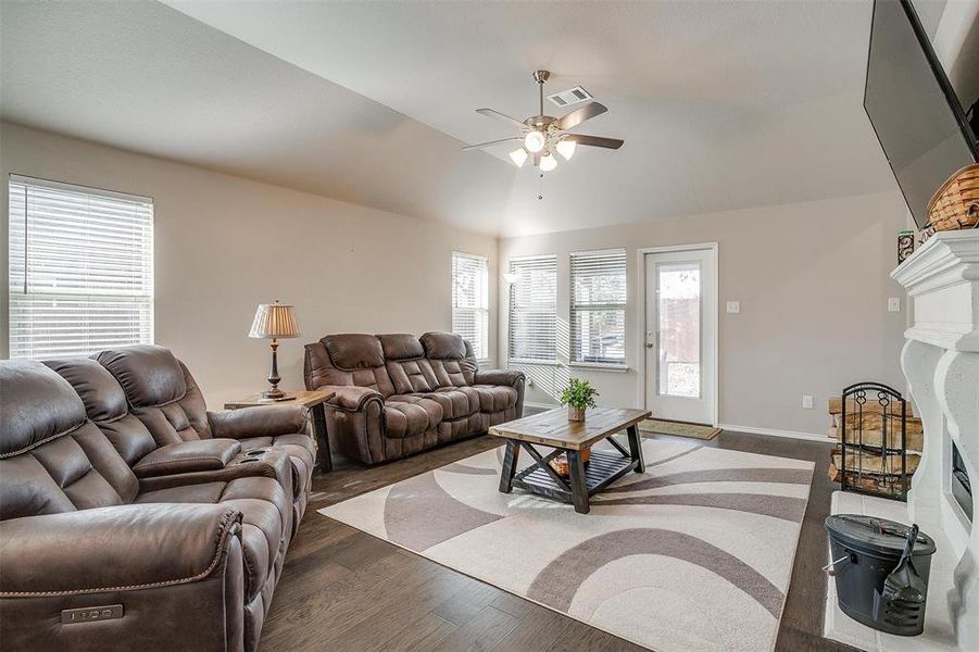 Living room with ceiling fan, dark hardwood / wood-style flooring, a healthy amount of sunlight, and vaulted ceiling