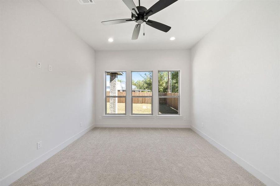 Spare room featuring ceiling fan and light colored carpet