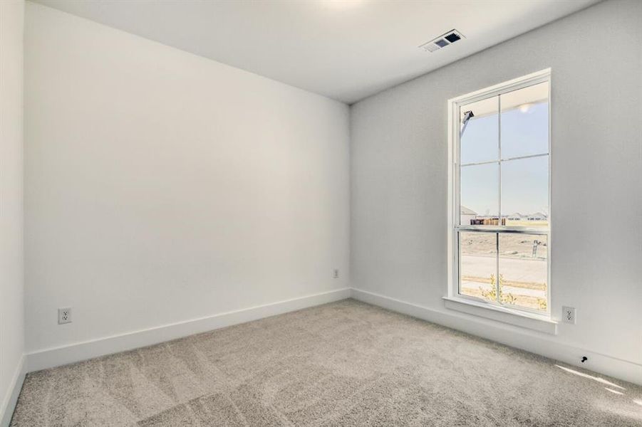 Spare room with light colored carpet and baseboards