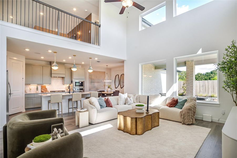This spacious, modern living area features high ceilings and abundant natural light. It flows seamlessly into a contemporary kitchen with a large island and stylish pendant lighting. The open layout and cozy seating make it ideal for entertaining or relaxing. This spacious, modern living area features high ceilings and abundant natural light. It flows seamlessly into a contemporary kitchen with a large island and stylish pendant lighting. The open layout and cozy seating make it ideal for entertaining or relaxing.