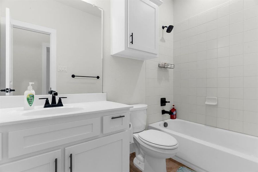 Bathroom featuring toilet, vanity, and bathing tub / shower combination Bathroom featuring toilet, vanity, and bathing tub / shower combination