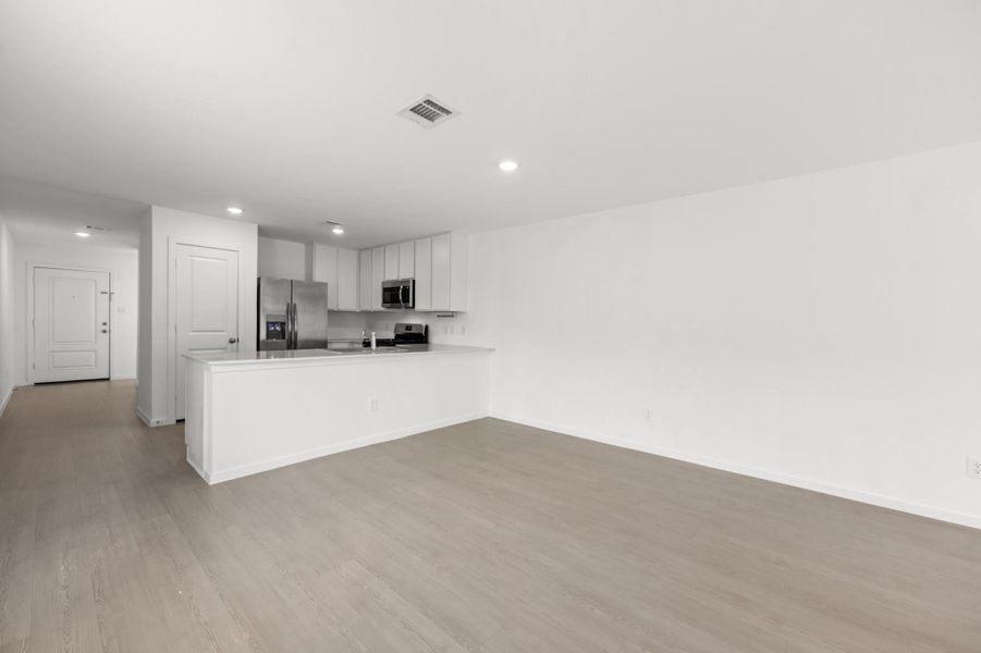 Bright dining space provides a natural transition between the kitchen and living room, complemented by continuous flooring and recessed lighting. Bright dining space provides a natural transition between the kitchen and living room, complemented by continuous flooring and recessed lighting.