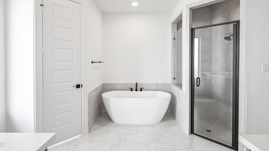 Full bathroom with a shower stall, a soaking tub, vanity, and recessed lighting Full bathroom with a shower stall, a soaking tub, vanity, and recessed lighting